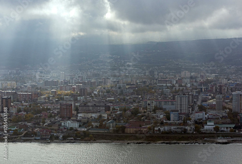 Aerial view of beautiful coastal cityscape with buildings and water under a cloudy sky, Makhachkala, Russia. photo