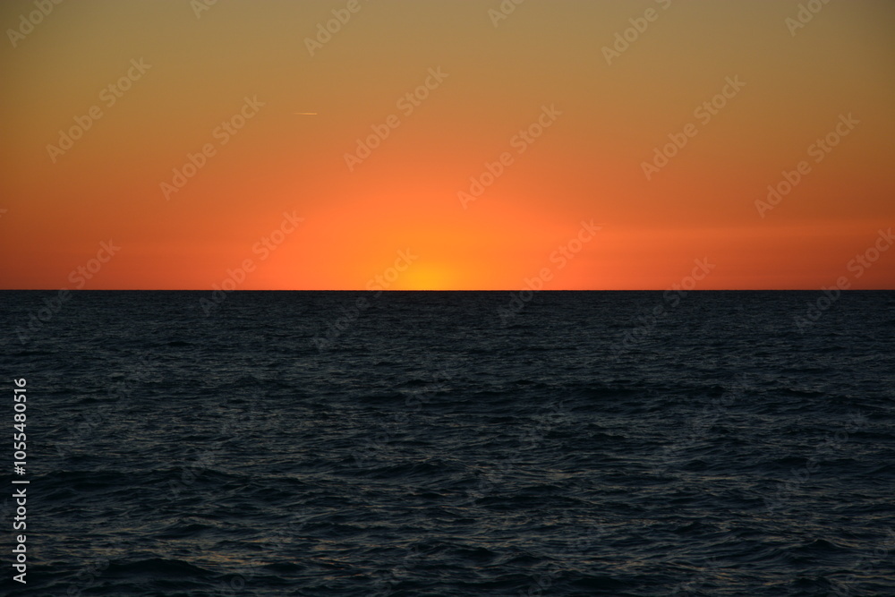 Coucher du soleil sur la plage avec ciel dégagé sur l'océan atlantique en été à Labenne-Océan dans les Landes Coucher du soleil sur la plage avec ciel dégagé sur l'océan atlantique en été à Labenne-Océan dans les Landes