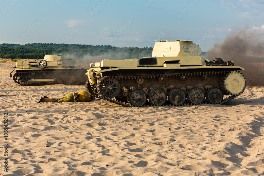 Fototapeta premium Two German tanks on the battlefield in the sand, dust and smoke.. Reconstruction siege of Tobruk durind WWII. Błędów desert, Silesia, Poland