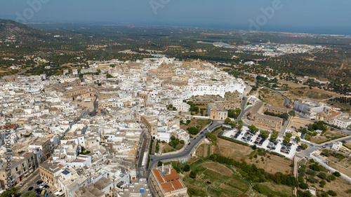 Aerial view of the historic center of Ostuni, also known as The White Town. The Old Town is located on a hill in the province of Brindisi, in Puglia, Italy. In background is the Mediterranean sea.