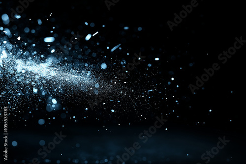 Blue glitter particles in motion on black background