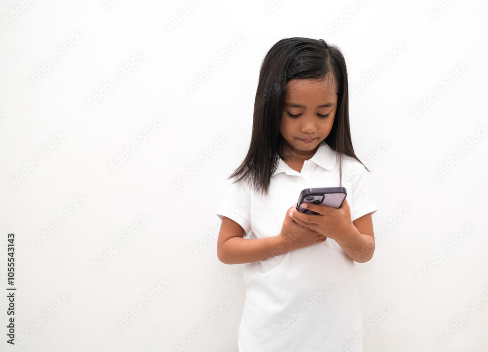 beautiful asian little girl on white background holds mobile phone, uses modern cellular beautiful asian little girl on white background holds mobile phone, uses modern cellular