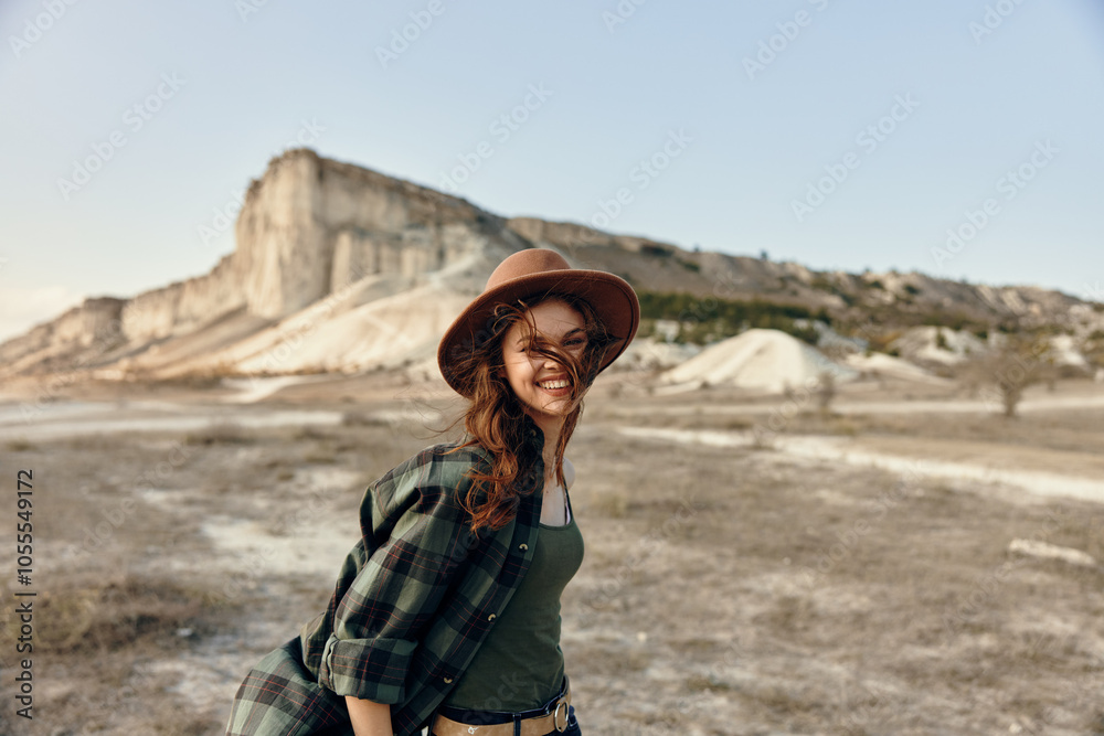 Woman in plaid shirt and hat admiring majestic mountain range on a sunny day Woman in plaid shirt and hat admiring majestic mountain range on a sunny day