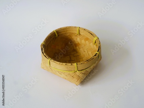 Indonesian traditional besek or a food container made of woven bamboo isolated white background. DIY  food container usually used for traditional event photo