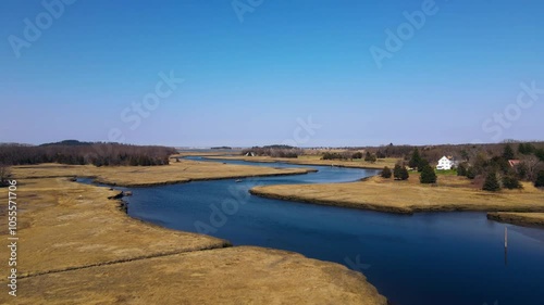 Aerial view of serene winding river surrounded by lush trees and expansive countryside under a blue sky, South Essex, United States of America. photo