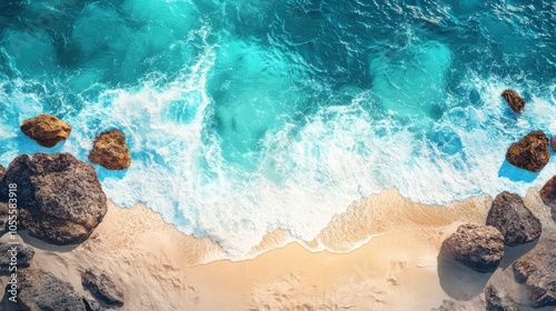 Top-down view of a rocky coastline with sandy coves and blue-green waters, perfect for a tranquil beach holiday template, with the waves softly washing the shore.