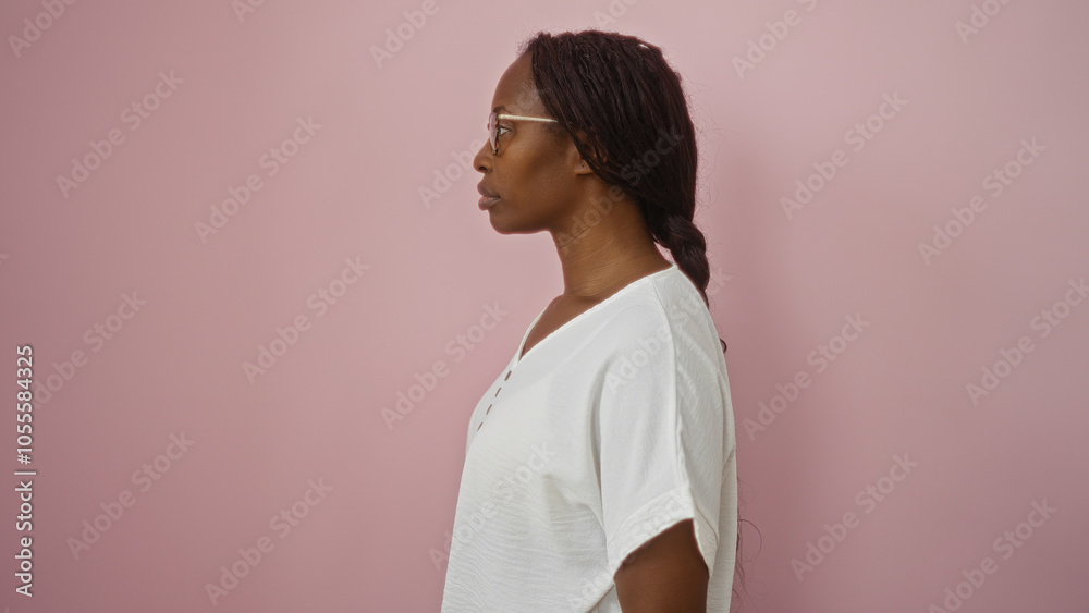 Young, beautiful, african, american woman in white shirt standing against isolated pink background, exuding attractiveness and elegance. Young, beautiful, african, american woman in white shirt standing against isolated pink background, exuding attractiveness and elegance.