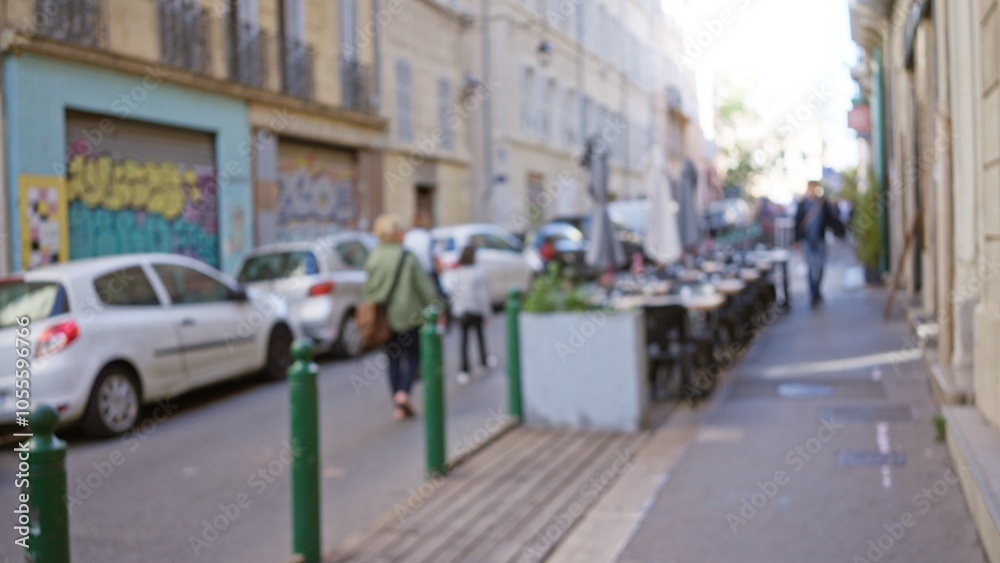 Blurred street scene in marseilles with people walking by graffiti-covered walls and parked cars, creating a vibrant urban atmosphere. Blurred street scene in marseilles with people walking by graffiti-covered walls and parked cars, creating a vibrant urban atmosphere.