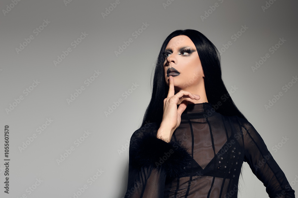 A fashionable drag queen exudes confidence in a stylish black outfit, striking a pose in a studio setting. A fashionable drag queen exudes confidence in a stylish black outfit, striking a pose in a studio setting.
