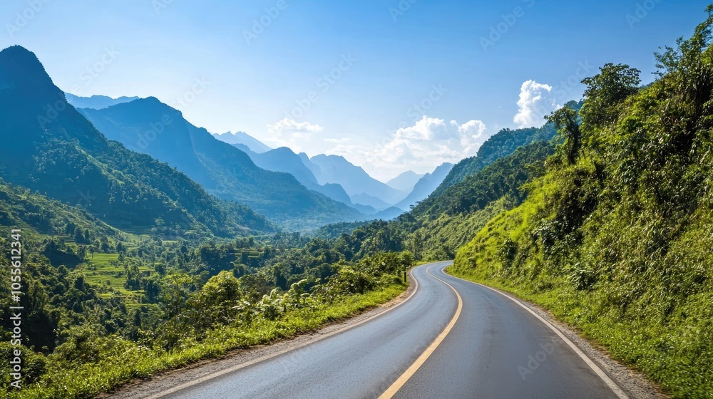Lush green mountains rise alongside a deserted asphalt road beneath a clear blue sky Lush green mountains rise alongside a deserted asphalt road beneath a clear blue sky