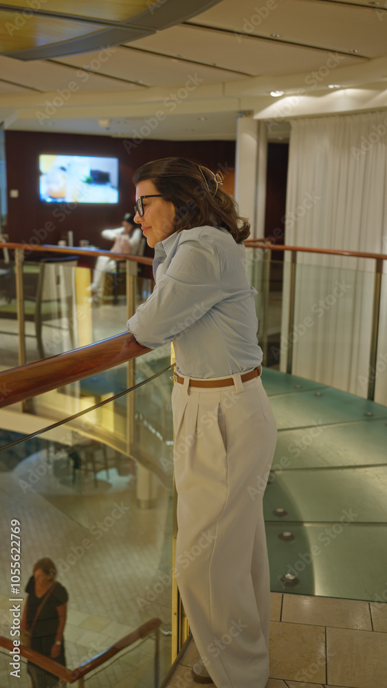 Woman standing on luxury cruise indoors watching view in a hall showcasing elegance and relaxation on a stylish journey. Woman standing on luxury cruise indoors watching view in a hall showcasing elegance and relaxation on a stylish journey.