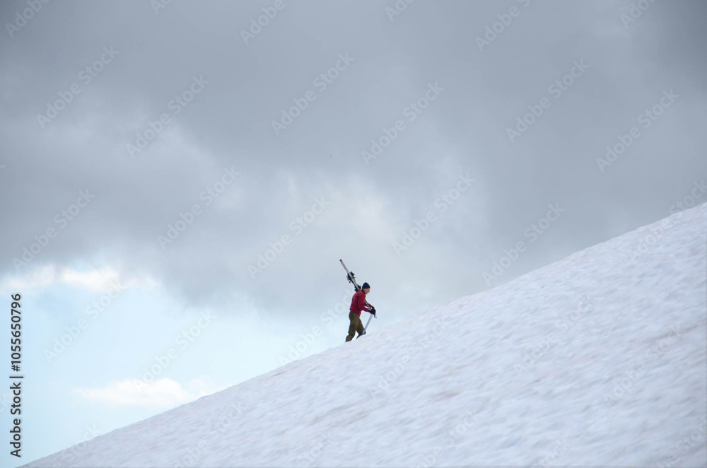 A skier with skis goes up a mountain A skier with skis goes up a mountain