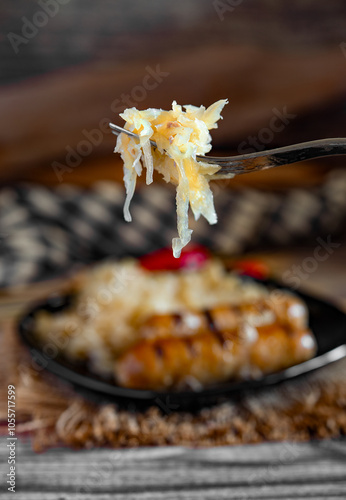 Grilled sausages with sauerkraut wrapped in aluminum foil on rustic wooden table