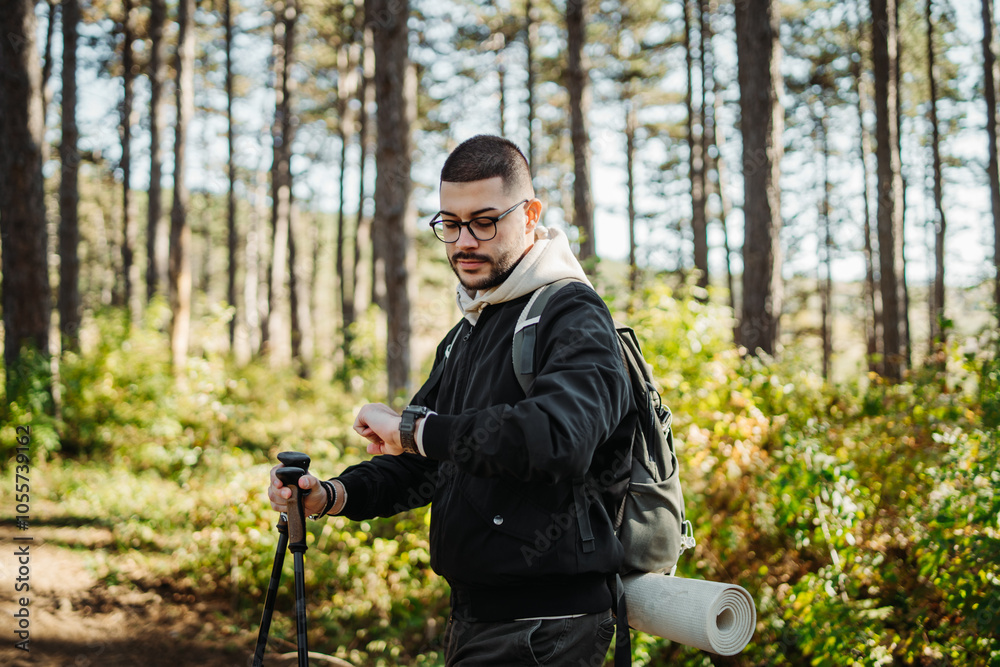 Young caucasian man hiking or trekking through the forest Young caucasian man hiking or trekking through the forest