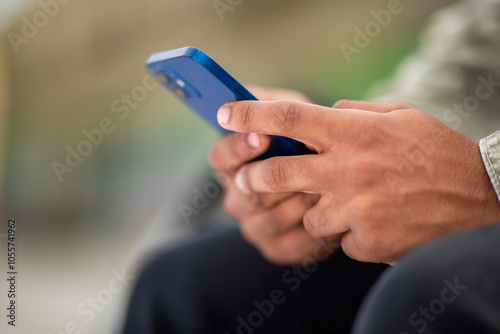 Person holding a blue smartphone in both hands