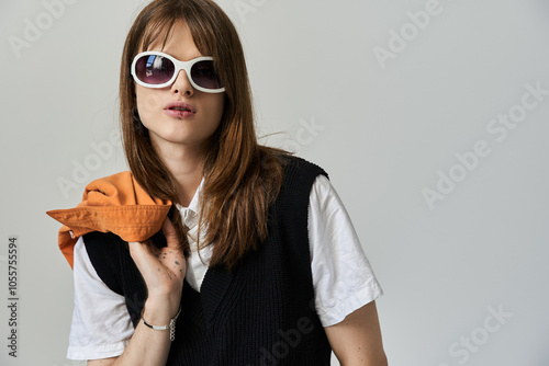 A young fashionable man showcases his style with oversized sunglasses and a vibrant top. photo