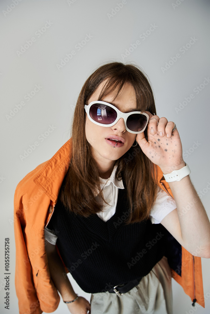 A fashionable young man showcases his trendy outfit and sunglasses with a confident pose. A fashionable young man showcases his trendy outfit and sunglasses with a confident pose.
