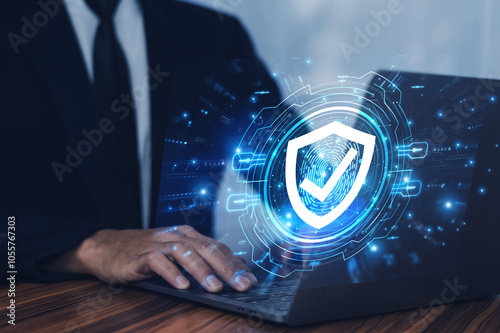 Man working on a laptop with advanced cyber security shield, ensuring the protection of sensitive data and securing the digital environment against potential threats.