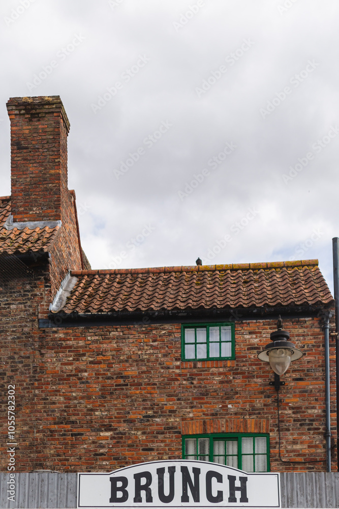 View of picturesque brick buildings with chimneys and street lamps in a quaint urban scene, York, England.