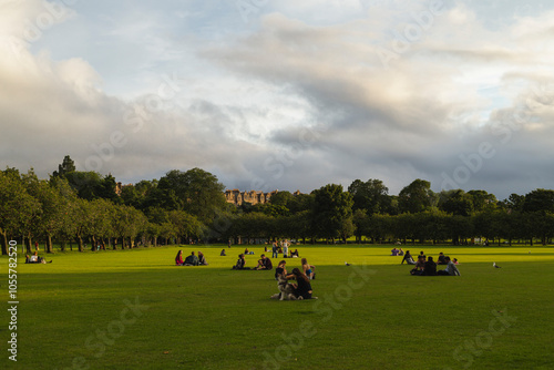 Edinburgh, Scotland - 05 August 2024: View of a scenic urban park with green grass, trees, and people relaxing under a tranquil sky, Edinburgh, Scotland.