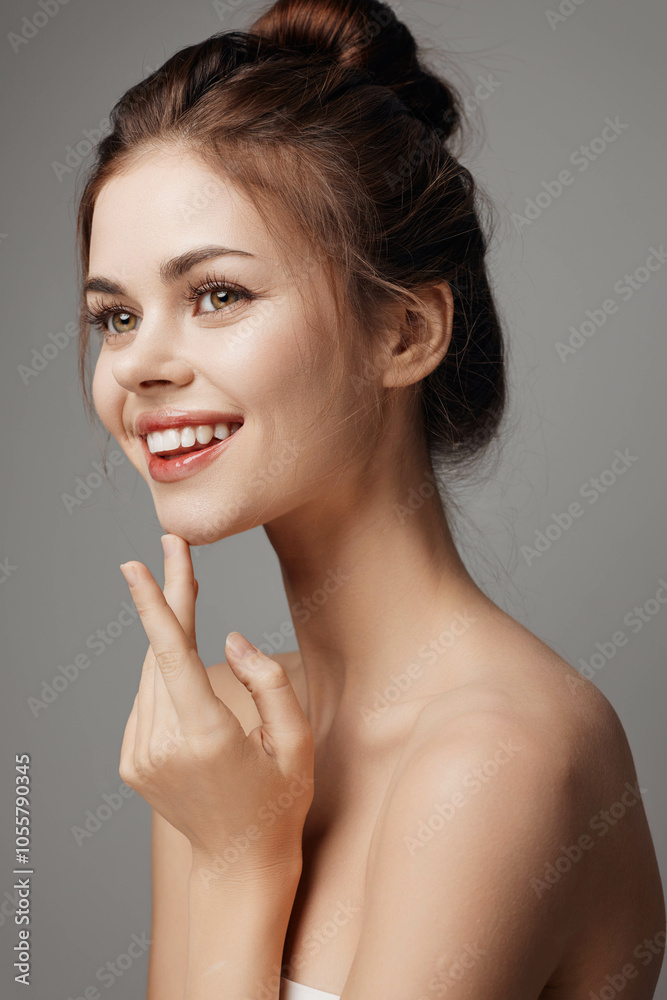 Beautiful young woman smiling and posing with her hand on her chin, looking at the camera Beautiful young woman smiling and posing with her hand on her chin, looking at the camera