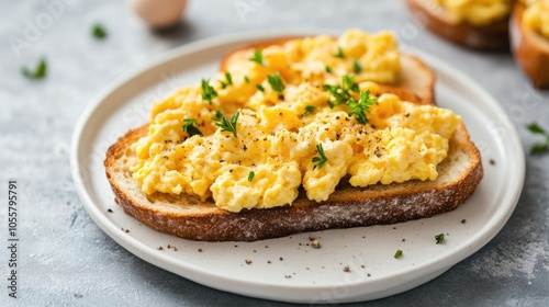 Scrambled eggs on toast presented on a white dish Breakfast idea photo