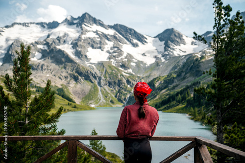 A tourist girl in a red shirt looks at the beautiful mountains in . Siberia. Altai photo