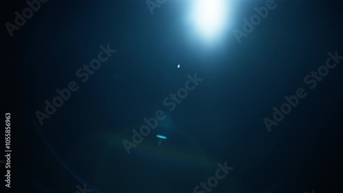 Abstract blue lens flare on black background. Slow motion. 