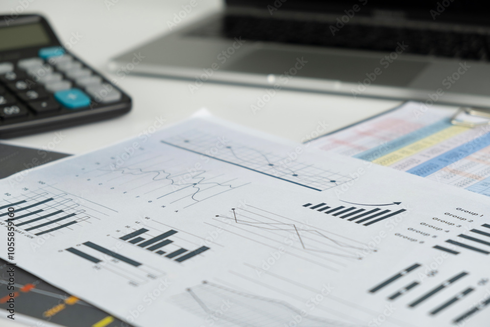 A modern office desk with a laptop financial reports A modern office desk with a laptop financial reports