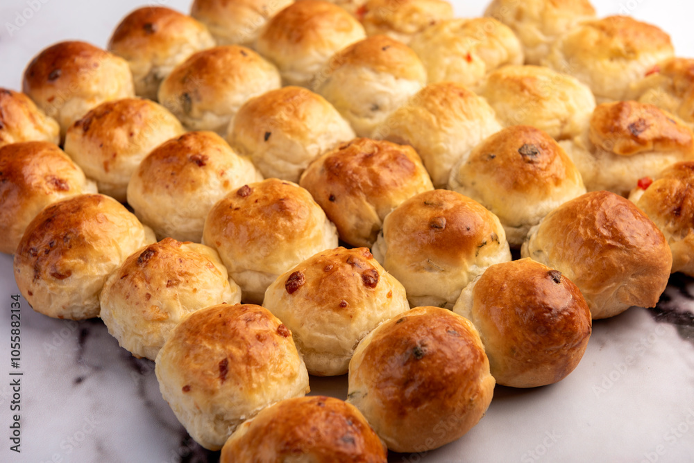 Homemade breads flavored with oregano, bell pepper, onion and cheese on a kitchen counter with ingredients Homemade breads flavored with oregano, bell pepper, onion and cheese on a kitchen counter with ingredients