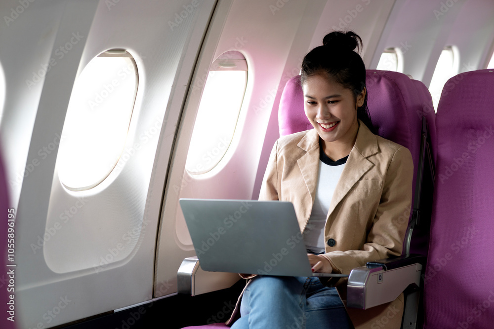 young businesswoman uses laptop while flying airplane for work young businesswoman uses laptop while flying airplane for work