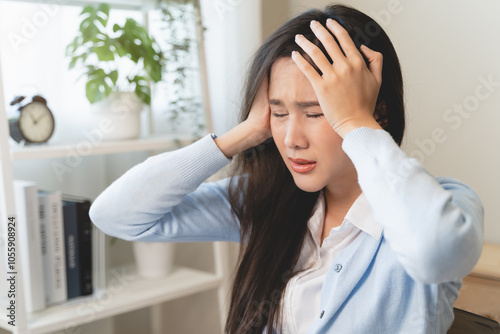 Young woman feeling headache during work in the office.