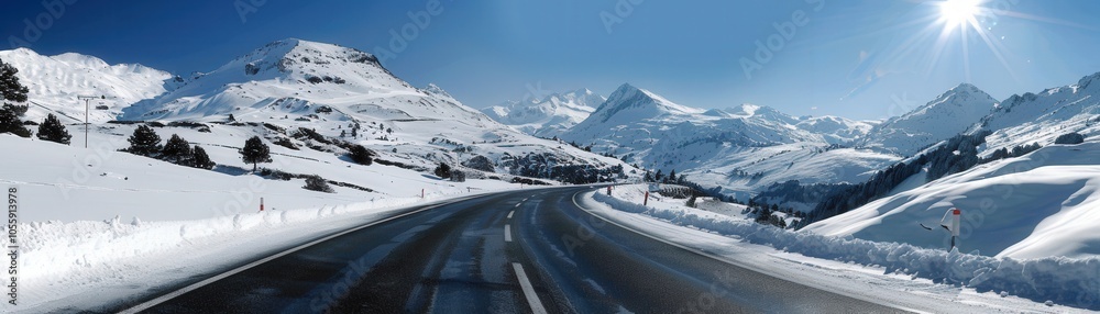 A snowy mountain range is in the background of a road