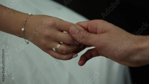bride's hand with a wedding ring on a wedding dress