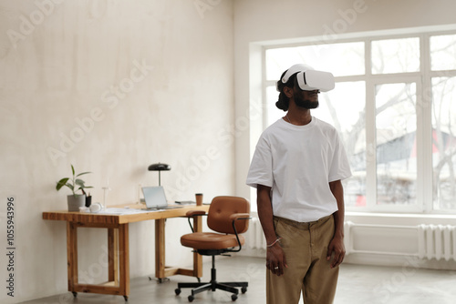 Young male architect wearing VR headset, engaged in virtual activity photo