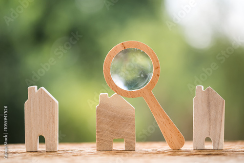 Many home model and magnifying glass put on the old wood on bokeh background, Loan for real estate and searching for choose the buy a new house to family in the future concept.