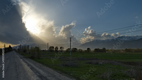 Kyrgyzstan, Karakol. A gloomy view of the setting sun behind heavy storm clouds on the shore of Lake Issyk-Kul.