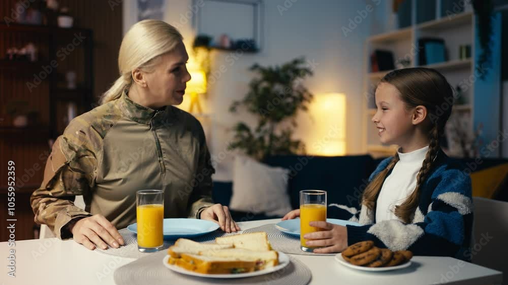 Caring military mom and her little daughter eating lunch together, family love Caring military mom and her little daughter eating lunch together, family love