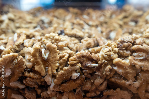 Walnut background. Peeled walnuts on display at a grocery store. Closeup view on shelled walnuts selling by weight in food store.