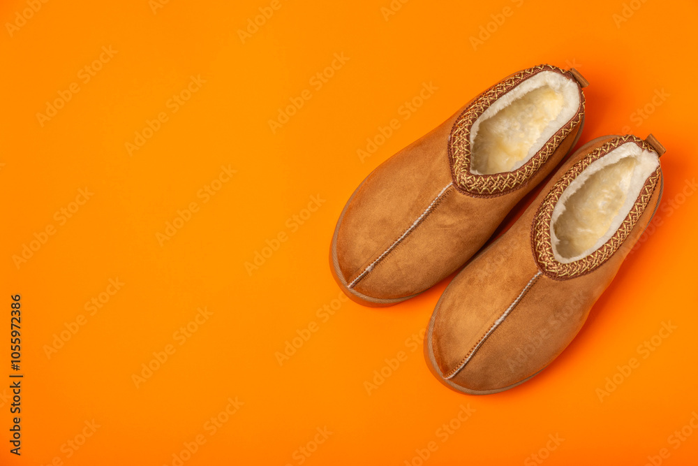 Fototapeta premium Soft slippers on a bright colored background, close-up. House slippers. Comfortable shoes for home. Foot care concept. Home comfort. Space for text. Copy space.