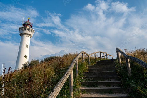 Lighthouse and a staircase with wooden railing in the dunes of the Dutch town of Egmond aan Zee