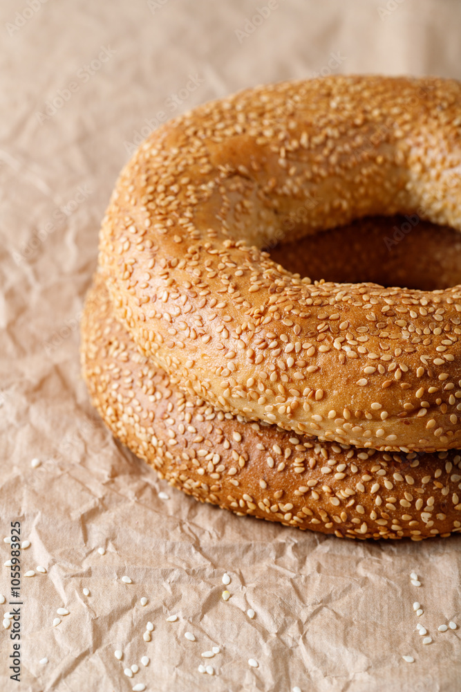 Two traditional turkish whole simit sesame bagels on paper background. Two traditional turkish whole simit sesame bagels on paper background.
