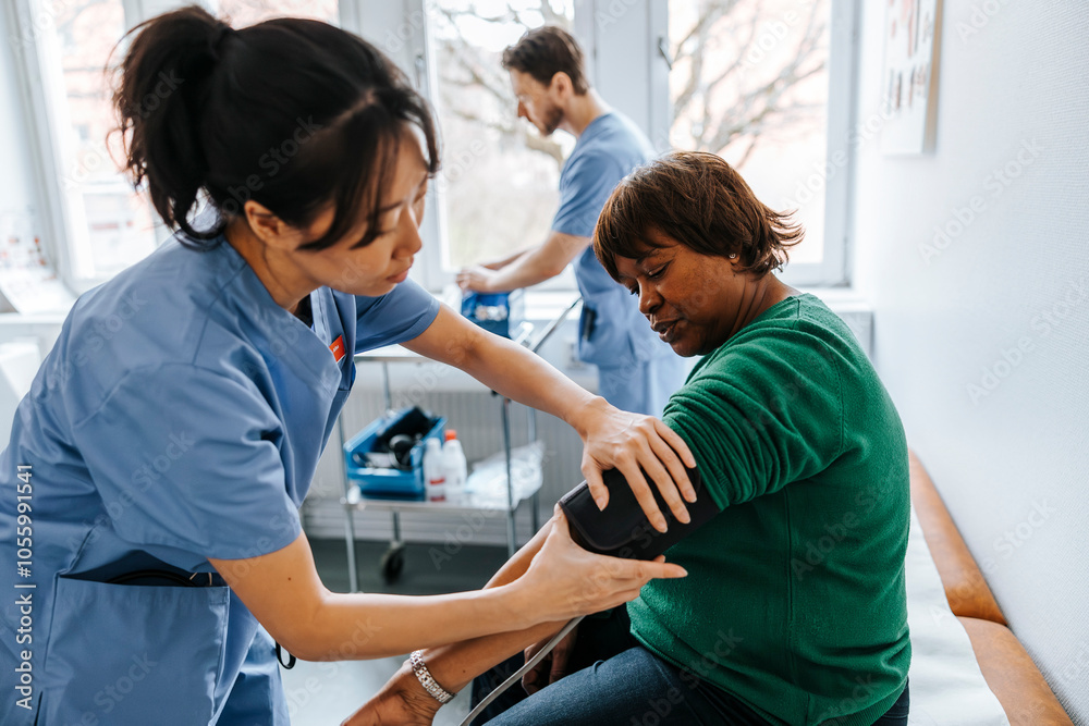 Female healthcare worker checking senior patient's blood pressure in medical examination room Female healthcare worker checking senior patient's blood pressure in medical examination room