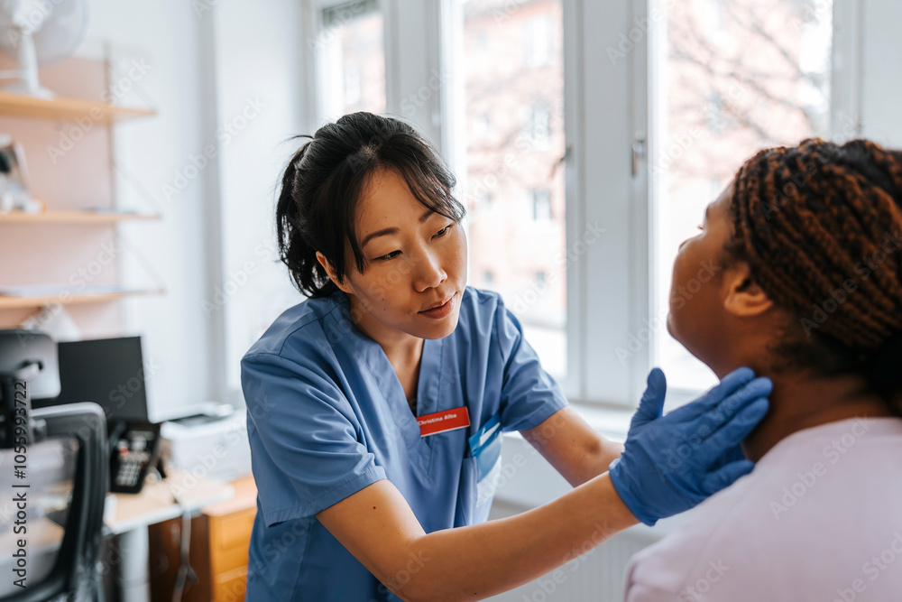 Female medical expert checking lymph nodes of young patient in examination room at hospital Female medical expert checking lymph nodes of young patient in examination room at hospital
