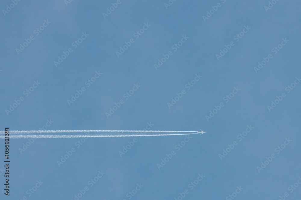 A jet airplane flying at high altitude, leaving a clean, straight contrail across the clear blue sky. The minimalist scene evokes freedom and simplicity in open airspace. A jet airplane flying at high altitude, leaving a clean, straight contrail across the clear blue sky. The minimalist scene evokes freedom and simplicity in open airspace.