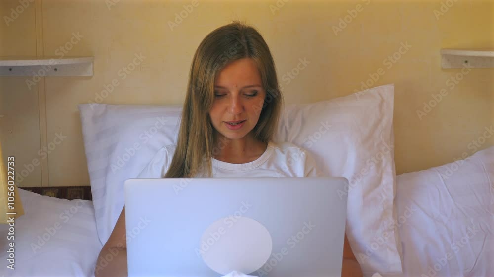Woman working from home on laptop while sitting comfortably on bed, demonstrating changing landscape of remote work. Remote Work and Home Office Woman working from home on laptop while sitting comfortably on bed, demonstrating changing landscape of remote work. Remote Work and Home Office