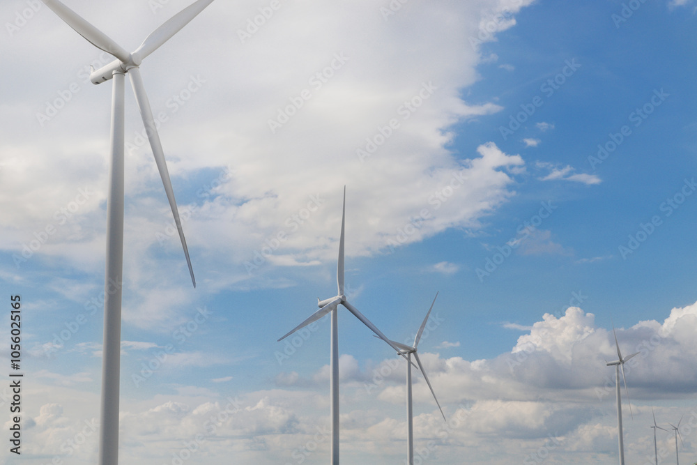 Wind turbine farm with cloudy blue sky on sunny day. High wind turbines park for generation electricity. Sustainable and alternative renewable energy, green energy concept. Wind turbine farm with cloudy blue sky on sunny day. High wind turbines park for generation electricity. Sustainable and alternative renewable energy, green energy concept.