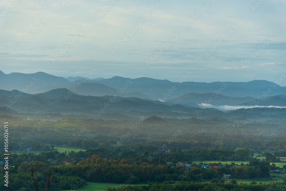 Obraz premium Dramatic sunset over mountain landscape. Beautiful landscape foggy hills twilight time. Blue golden sky sunrise dramatic beautiful landscape mountain. Dawn sky gold dusk time cloudscape with sunlight