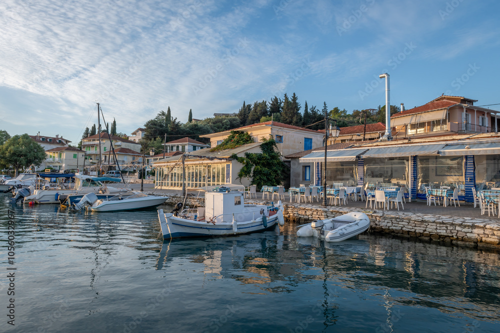 Obraz premium The seafront of Lygia village in dawn light, with fishing boats, sailing yachts, and restaurants famous for seafood in this traditional fishing village, Lefkada island, Greece.