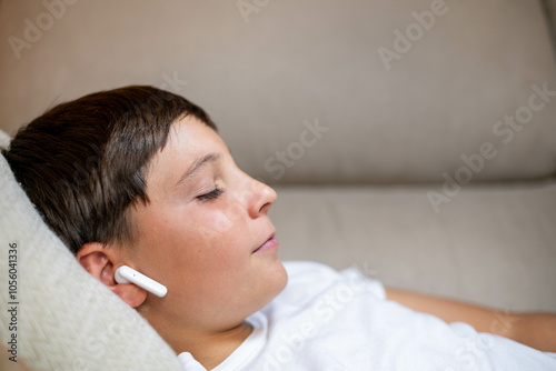 Close-up portrait of a sleeping boy listening to headphones